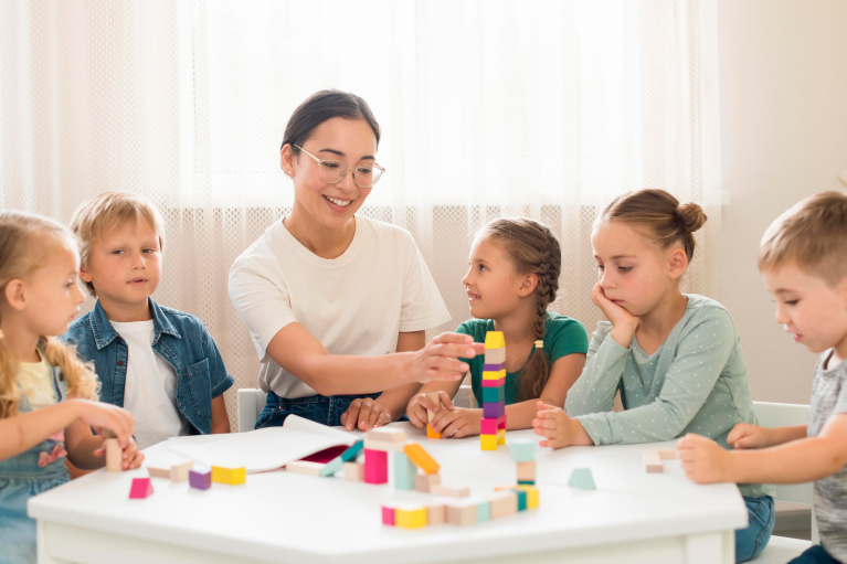 Montessori teacher conducting classroom activities with preschool children while demonstrating early childhood education skills